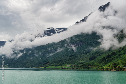 Norwegian mountain lake, located near the town of Olden.  The lake is surrounded by mountains, with low hanging clouds drifting past them photo