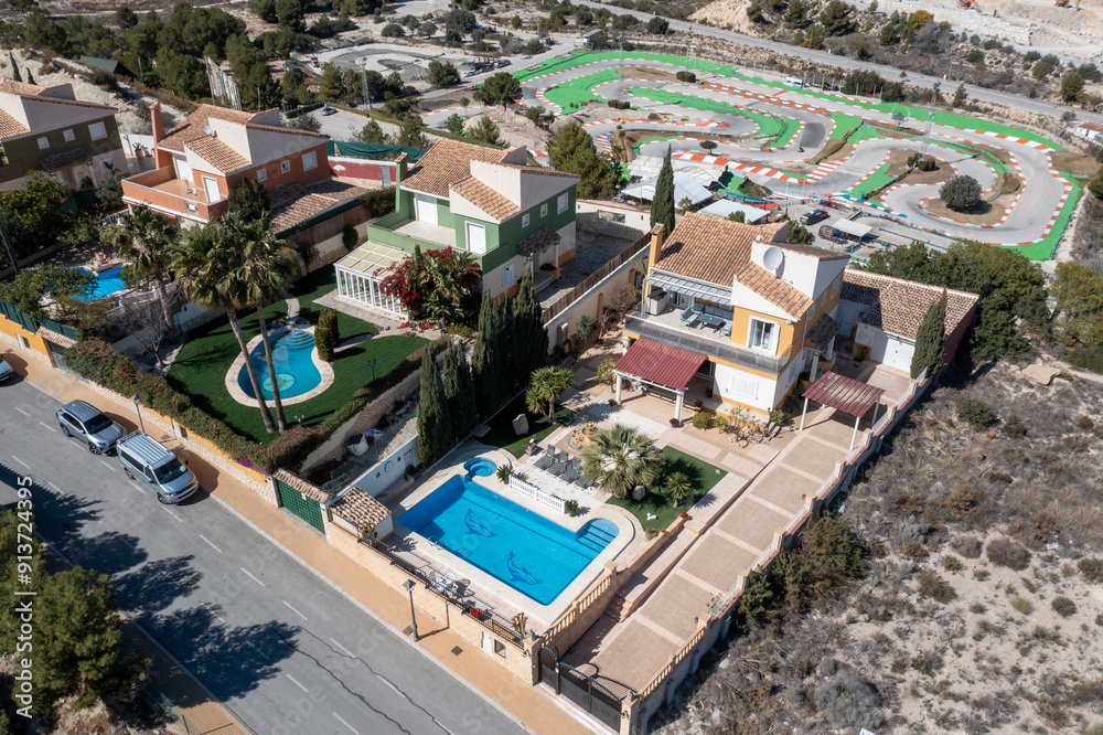 Fototapeta premium Aerial drone photo of a beautiful villa in the city of Benidorm in Spain showing the two story Spanish house with a swimming pool on a hot day in the summer time in the town of Finestrat