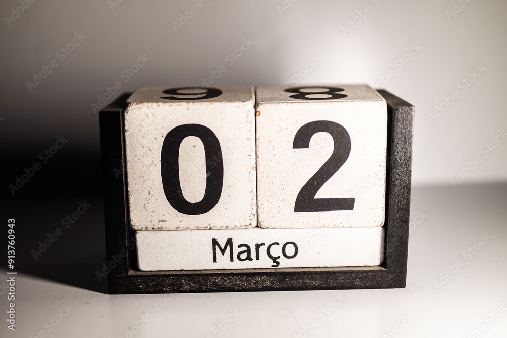 Close-up of a wooden desk calendar showing the date March 2nd in Portuguese. Close-up of a wooden desk calendar showing the date March 2nd in Portuguese.