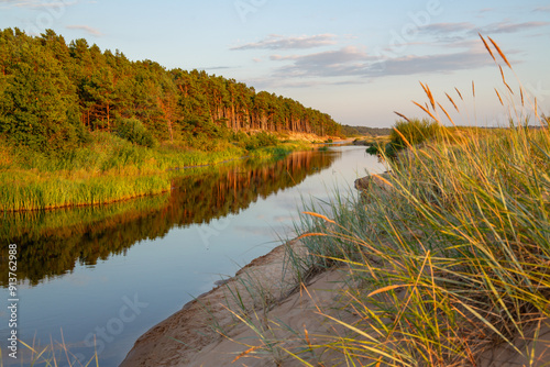 Sunset moment at the river Vitrupe at the beach of Baltic sea in August in Latvia photo