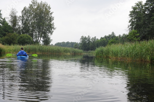 Kayaking in a kayak on Krutynia river in summer with green trees in Poland, Europe photo