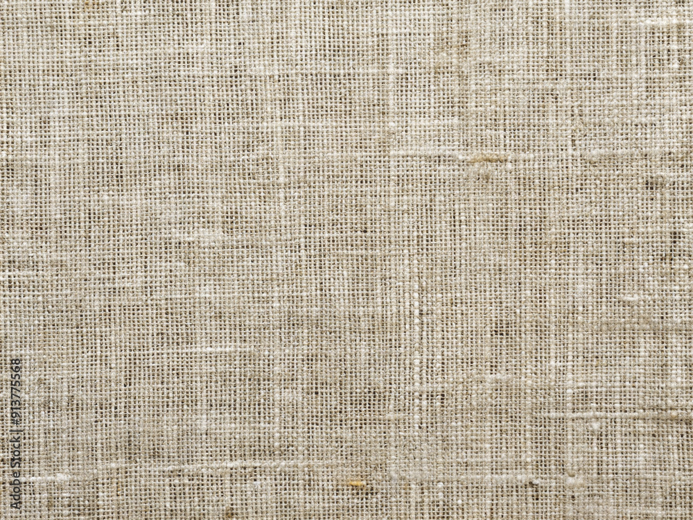 Fototapeta premium Weathered organic linen fabric features a subtle ecru flax pattern, showcasing a rough, textured weave and natural gray tones, perfect for wallpaper or backgrounds.