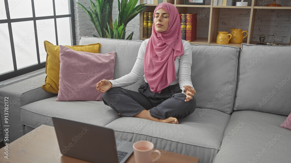 Obraz premium Serene woman meditating on a couch in a cozy living room, reflecting tranquility and mindfulness.