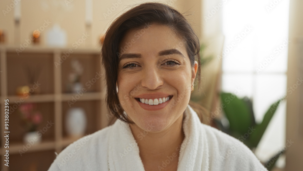 Woman smiling indoors at a spa wearing a white robe, showcasing a beautiful and relaxed atmosphere in the wellness center. Woman smiling indoors at a spa wearing a white robe, showcasing a beautiful and relaxed atmosphere in the wellness center.