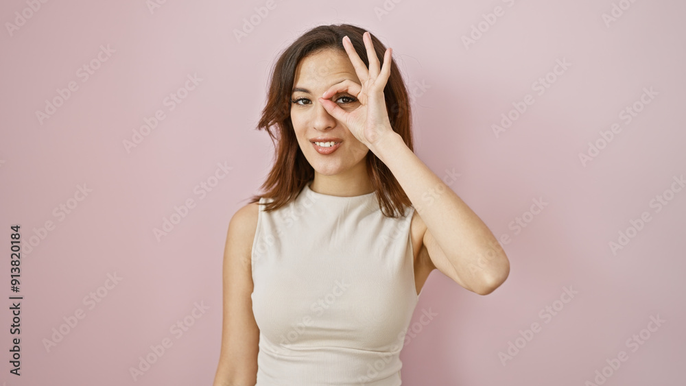 Happy young hispanic woman making okay gesture against a pink isolated background Happy young hispanic woman making okay gesture against a pink isolated background