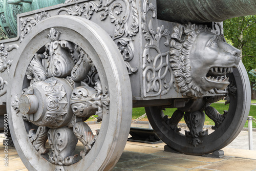 Ancient Tsar Cannon of enormous size was erected as monument on territory of the Moscow Kremlin. Close-up of cannon carriage with carved wheels and head of animal. Moscow, Russia – June 14, 2024