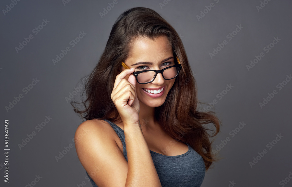 Girl, portrait and happy with eyeglasses in studio on grey background for prescription, eyewear and eyesight. Female person, smile and satisfied or confident with frame for spectacles, lens or vision Girl, portrait and happy with eyeglasses in studio on grey background for prescription, eyewear and eyesight. Female person, smile and satisfied or confident with frame for spectacles, lens or vision