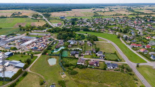 Drone photography of small town surrounded by forest during summer dusk