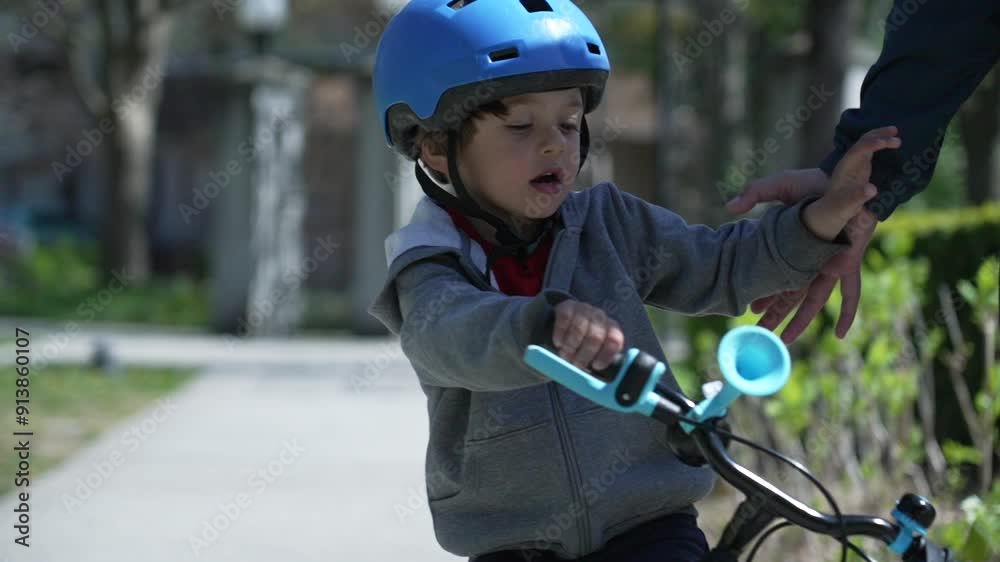 Young boy wearing a blue helmet losing balance and falling from his bike, guided by an adult, embodying the concept of trial and error while learning to ride, in a green park setting Young boy wearing a blue helmet losing balance and falling from his bike, guided by an adult, embodying the concept of trial and error while learning to ride, in a green park setting