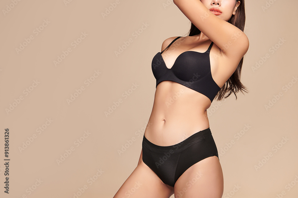 Obraz premium Confident beautiful young asian woman posing in black lingerie on beige background, Perfect body,