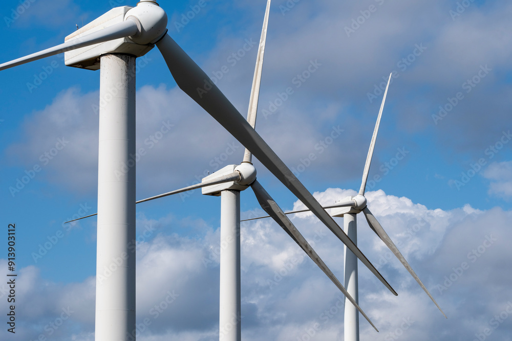 wind turbines against a blue sky, highlighting the sleek and modern design of these structures that silently convert wind into renewable energy for a greener future in Tarragona Spain wind turbines against a blue sky, highlighting the sleek and modern design of these structures that silently convert wind into renewable energy for a greener future in Tarragona Spain