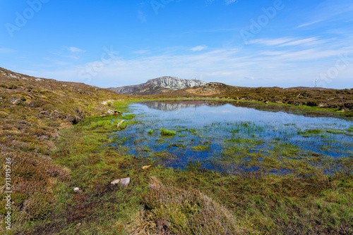 Across a shallow pool to a distant Holyhead mountain on Anglesey, Wales.