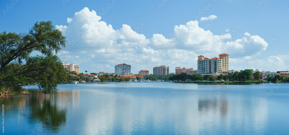 Vibrant Lakeside View of Urban Development Under Bright Blue Sky Vibrant Lakeside View of Urban Development Under Bright Blue Sky