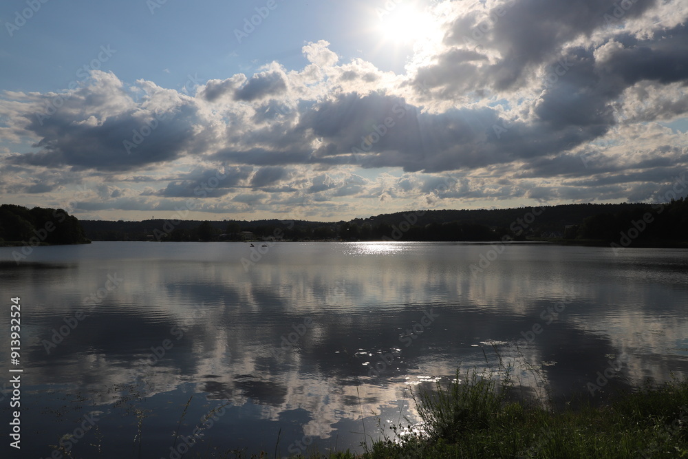monumental view of the lake with clouds and the setting sun reflected in the water