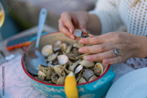 Woman eating seafood in a restaurant. Steamed mussels in white wine sauce. Food Concept photo