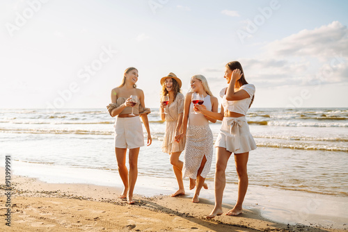 Quadro su tela Group of female friends having fun at on the beach, celebrating bachelorette party, drinking wine at sunset