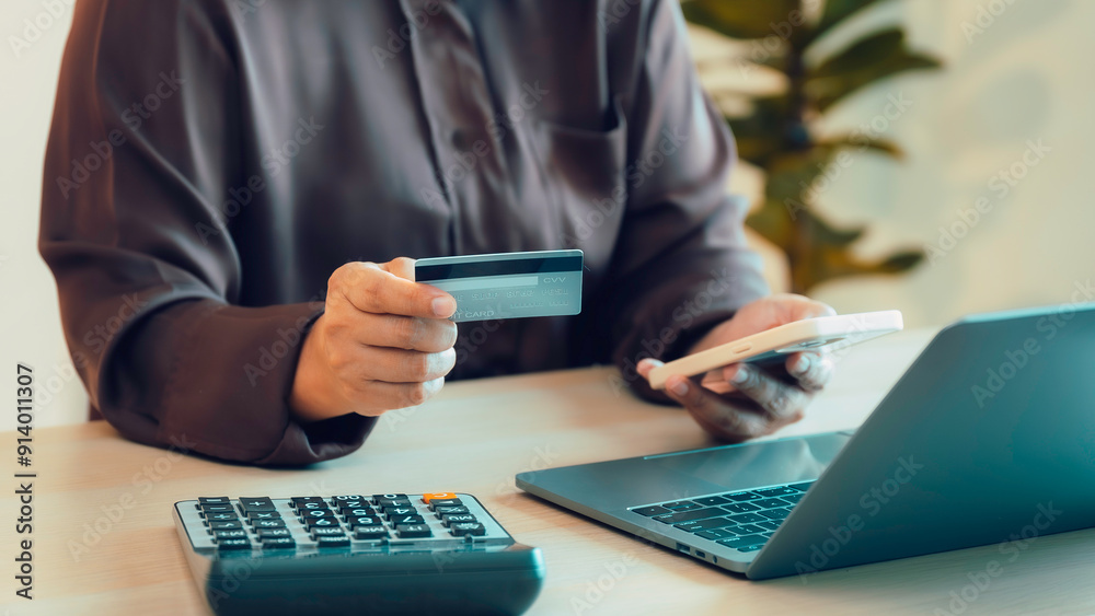woman holding credit card and doing online shopping sitting at home, her sing smartphone for mobile payments online shopping. Customer, internet payment with banking, ecommerce and smile or purchase