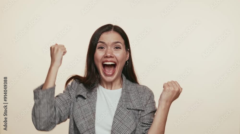 An exuberant businesswoman with raised fists, symbolizing success and victory in a professional setting. An exuberant businesswoman with raised fists, symbolizing success and victory in a professional setting.