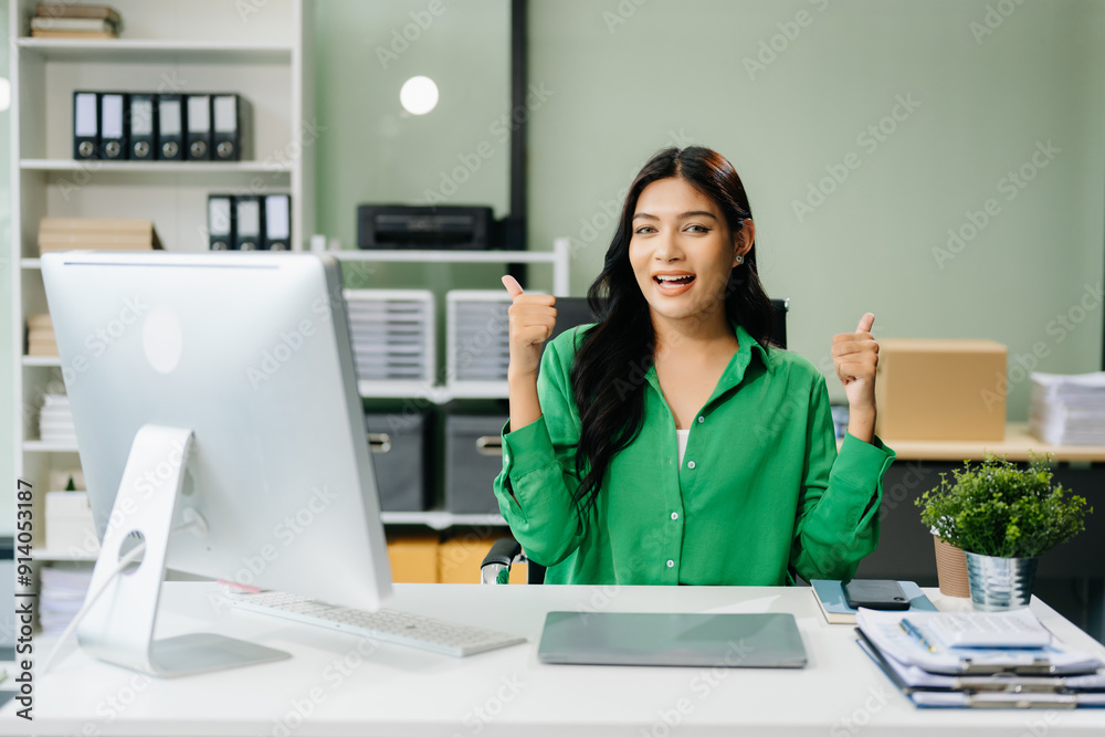 Young attractive Asian female office worker business suits smiling in office . Young attractive Asian female office worker business suits smiling in office .