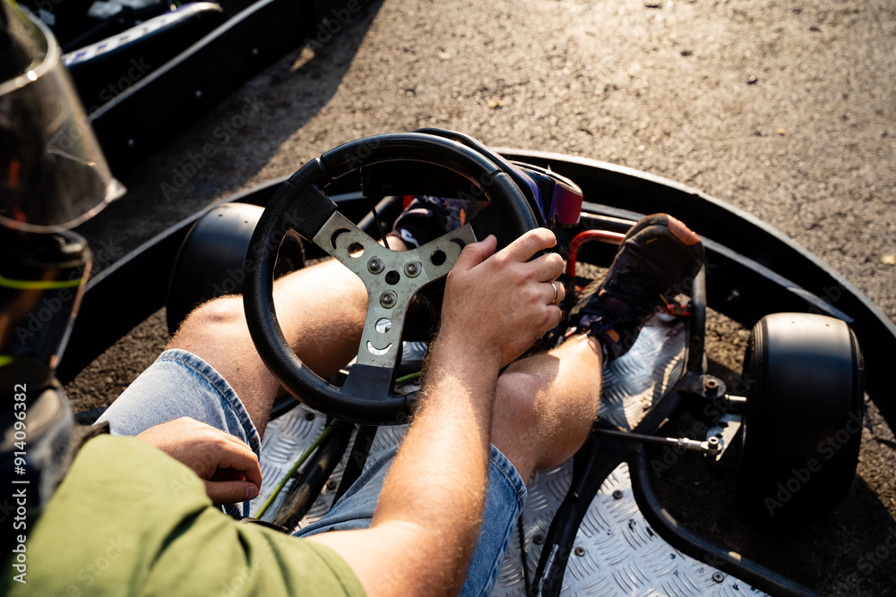 Obraz premium An experienced driver skillfully navigates a gokart on a winding road, enjoying the thrill of control and speed while maintaining balance through the challenging course