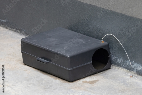 A black plastic rat trap on concrete floor. bait poison box for rat. photo