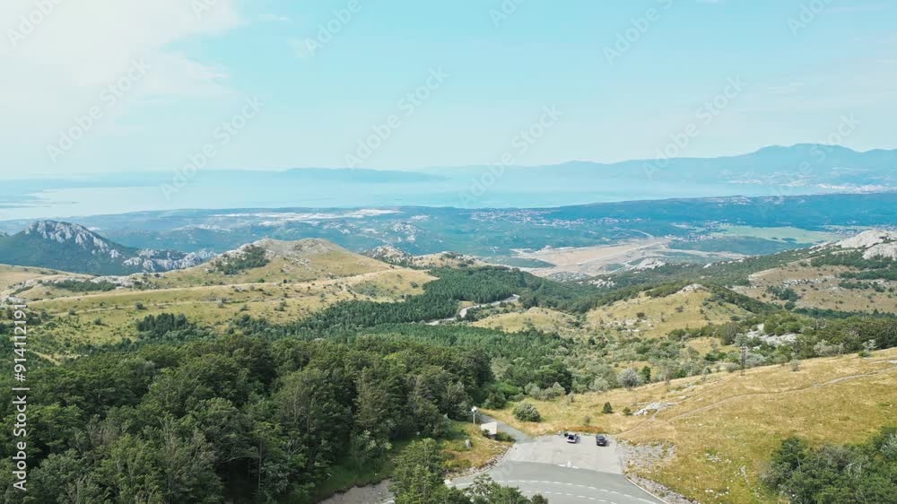 Aerial landscape with mountains and asphalt road between green forest Aerial landscape with mountains and asphalt road between green forest