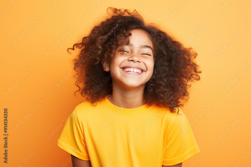 Happy young girl in a bright jacket against yellow background Happy young girl in a bright jacket against yellow background