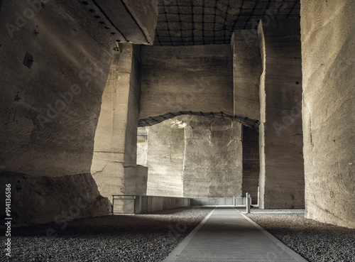 The Fertőrákosi Quarry in Hungary presents an impressive view with its towering stone walls and central walkway that guides visitors through this historic limestone extraction site.