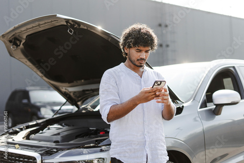 Indian man calling for assistance after a car breakdown in the city photo