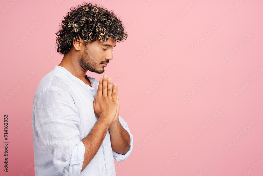 Attractive, pensive man praying with hope on pink background Attractive, pensive man praying with hope on pink background