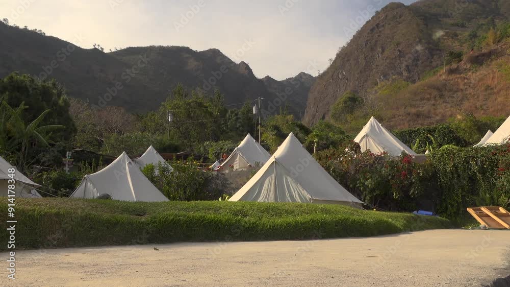 White tents at a hostel near mountains and a beach in tropical Guatemala on a sunny day White tents at a hostel near mountains and a beach in tropical Guatemala on a sunny day
