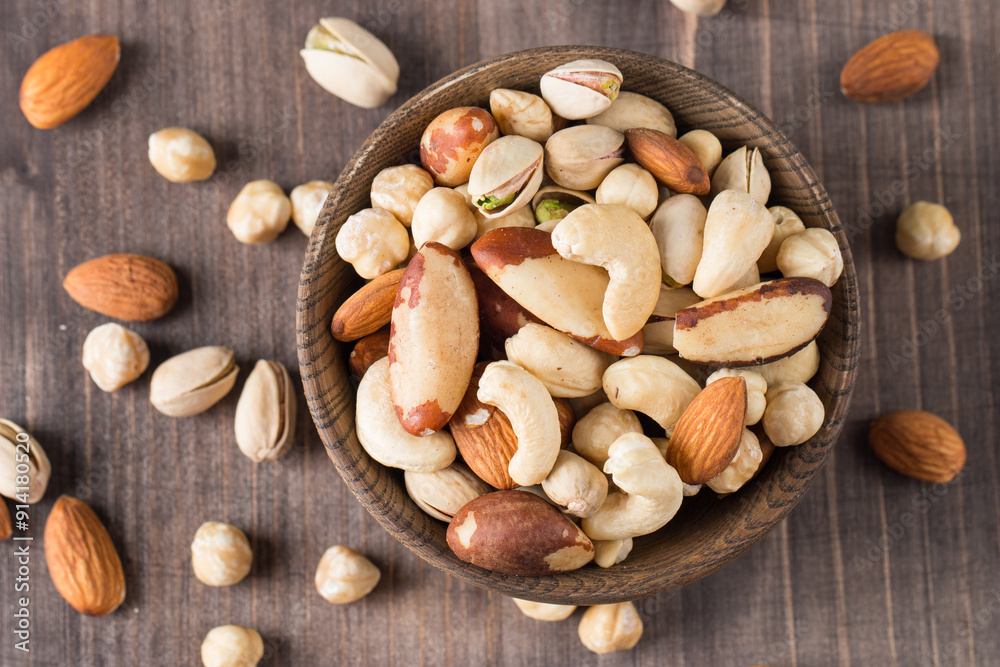 Healthy mix nuts on wooden background. Almonds, hazelnuts, cashews, peanuts, pistachios, Brazil nuts Healthy mix nuts on wooden background. Almonds, hazelnuts, cashews, peanuts, pistachios, Brazil nuts