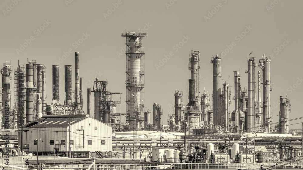 Oil refinery industry view details of pipes with valves in a large refinery isolated on blue sky Oil refinery industry view details of pipes with valves in a large refinery isolated on blue sky