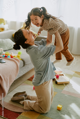 Canvastavla Young Asian mom lifting her daughter who laughing loudly