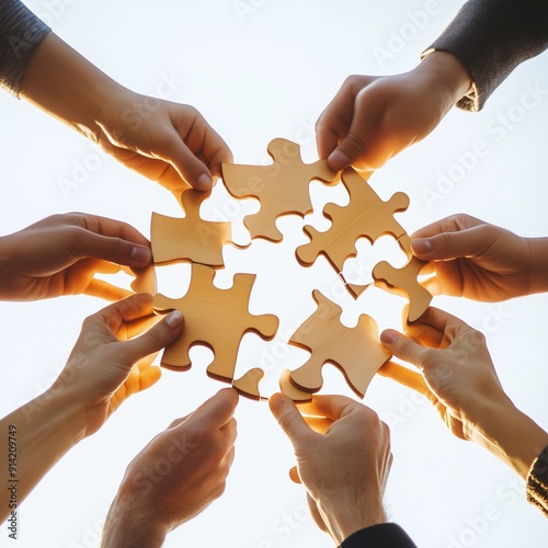 Hands Coming Together to Complete a Puzzle Against a Bright Background During Team Building Activity