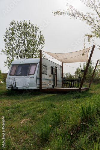 Caravan or camper trailer with Wooden Deck at Countryside Glamping Site. Outdoor Camping