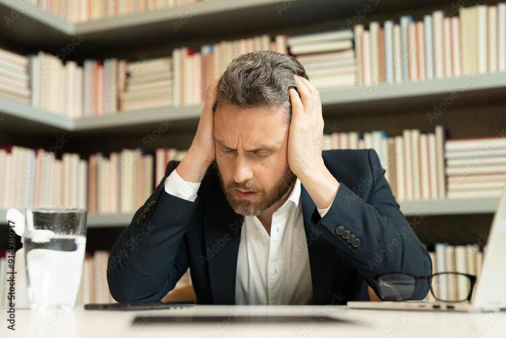 Business man got migraine touches her head because of pain. Man manager with strong headache working on laptop. Overworked freelancer or manager at office. Stressed, tired man with headache. Business man got migraine touches her head because of pain. Man manager with strong headache working on laptop. Overworked freelancer or manager at office. Stressed, tired man with headache.