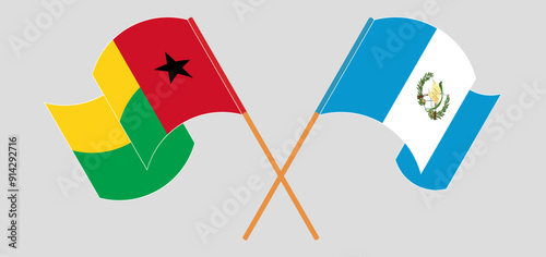 Crossed and waving flags of Guinea-Bissau and Republic of Guatemala