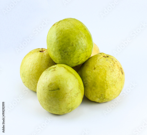 five half ripe red guavas on a white isolated background