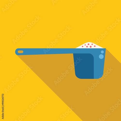 Blue plastic measuring cup holding washing powder on yellow background