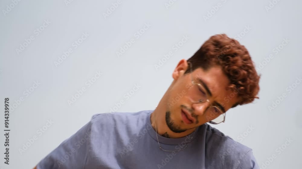 Young man stretching and preparing for exercise against clear sky backdrop