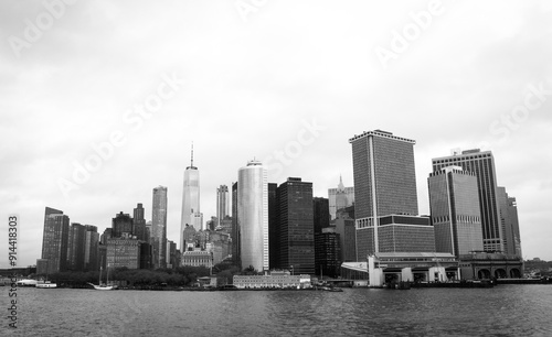 Black and white panoramic view of Manhattan's skyline from the Hudson River, featuring iconic skyscrapers on a cloudy day