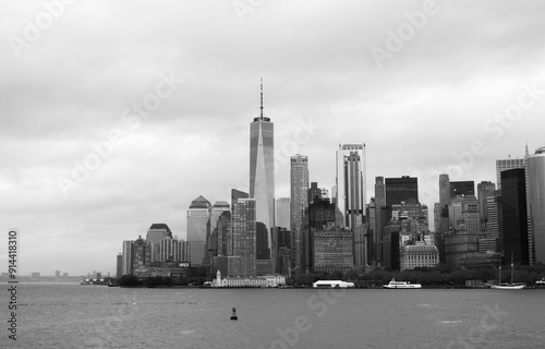 Black and white panoramic view of Manhattan's skyline from the Hudson River, featuring iconic skyscrapers on a cloudy day