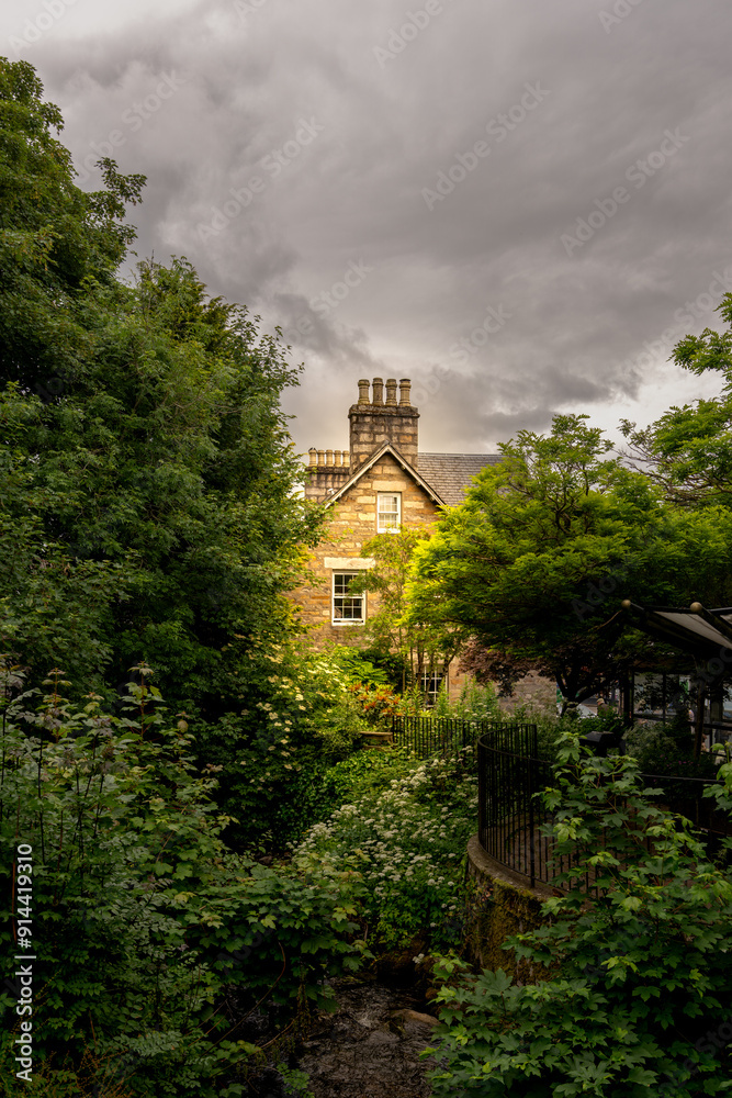 Obraz premium Pitlochry typical house between the trees. Highlands of Scotland. Scotland, United Kingdom. 
