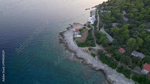 A stunning view captured by drone along the shores of the Mediterranean Sea. The beautiful Croatian coast during a summer vacation, with boats and yachts slicing through the sea waters.
