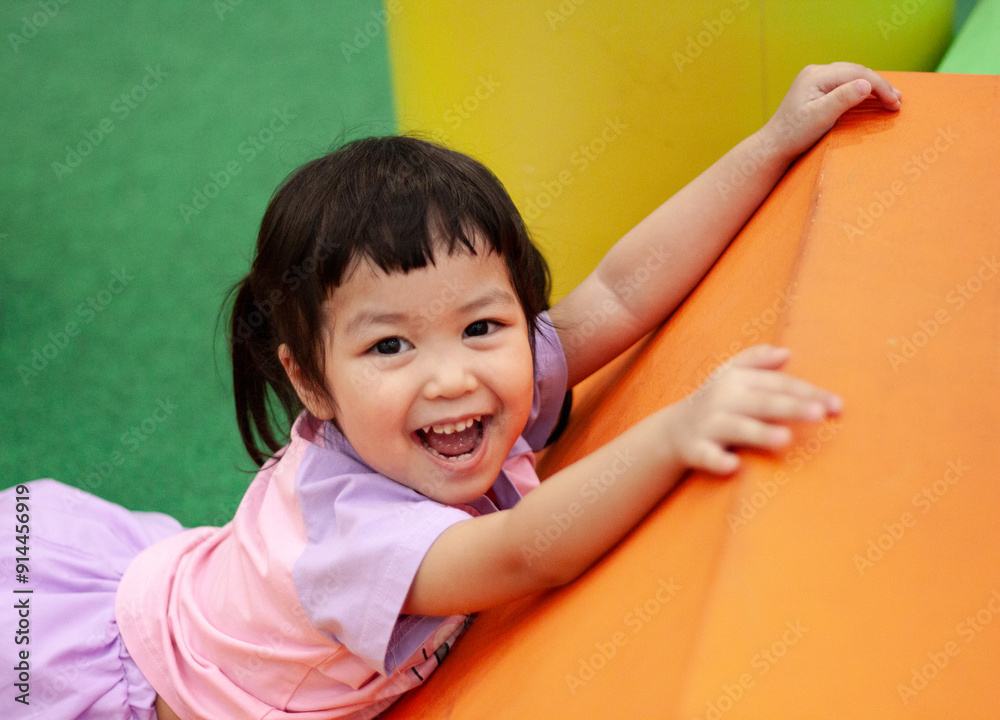 Happy asian child playing in indoor playground