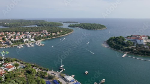 A stunning view captured by drone along the shores of the Mediterranean Sea. The beautiful Croatian coast during a summer vacation, with boats and yachts slicing through the sea waters.