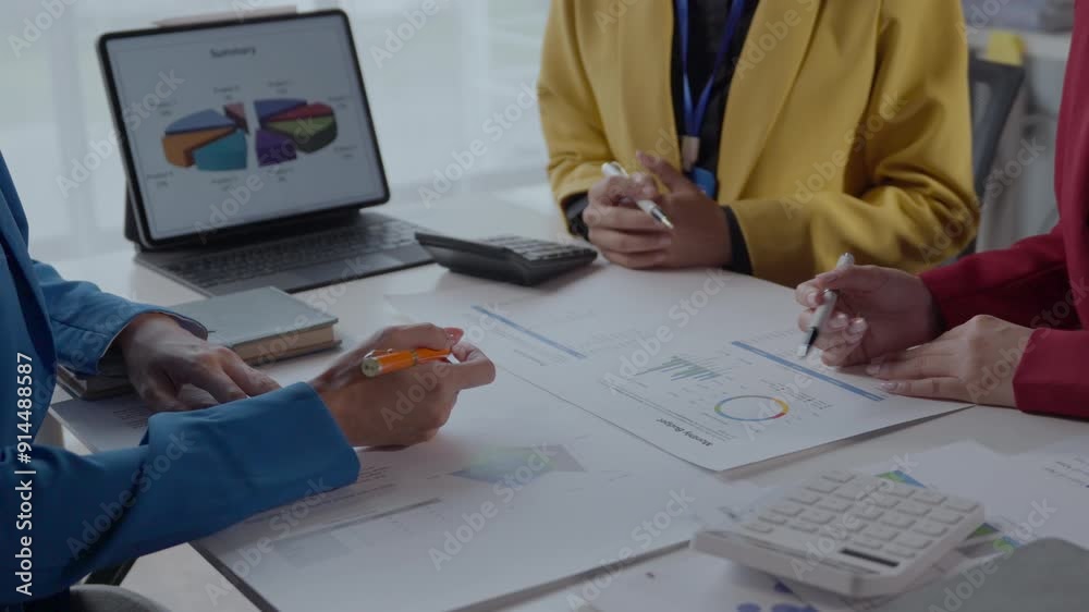 Diverse team discussing financial charts and graphs in a modern office ...