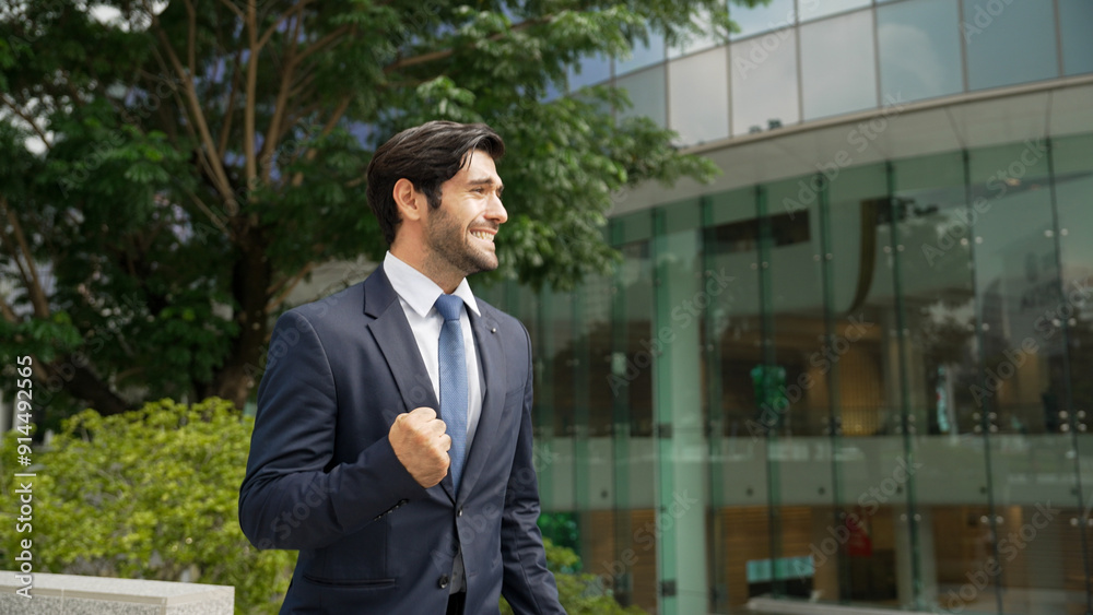 Successful business man celebrate getting a new position at building. Happy project manager smiling and proud about good news about successful project, winning prize, getting promotion. Exultant. Successful business man celebrate getting a new position at building. Happy project manager smiling and proud about good news about successful project, winning prize, getting promotion. Exultant.