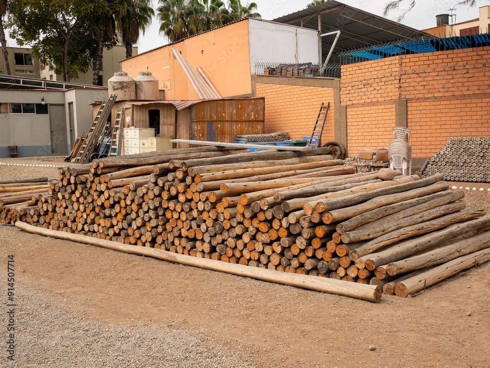 Stacked Logs Showing Bark with a Brick Wall Backdrop